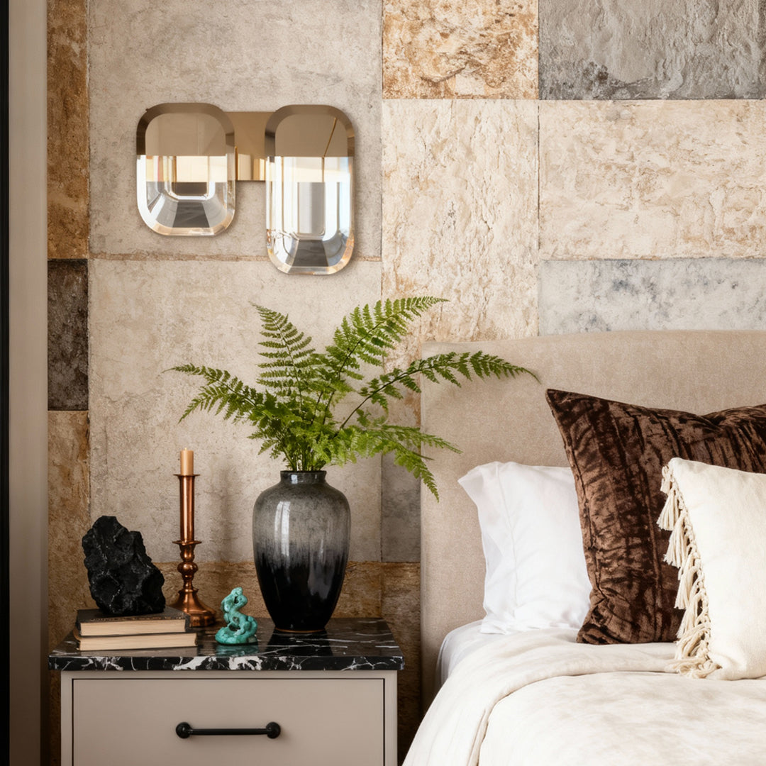 Crystal wall sconce lighting above nightstand in elegant bedroom with stone accent wall and botanical decor