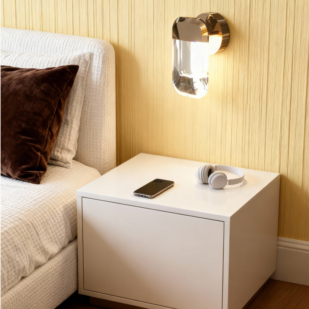 Crystal wall sconce lighting beside bed in minimalist bedroom with light wood paneling and contemporary styling