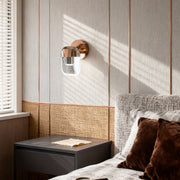 Crystal wall sconce lighting providing ambient illumination in textured bedroom with woven decor and neutral color palette