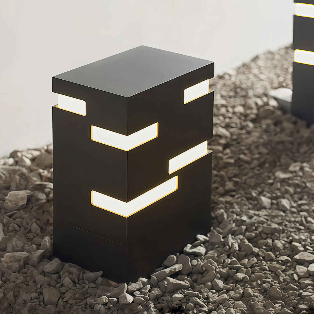 Cube-form black led bollard lights with multiple openings emitting warm light, ideal for contemporary pathways and outdoor decor.