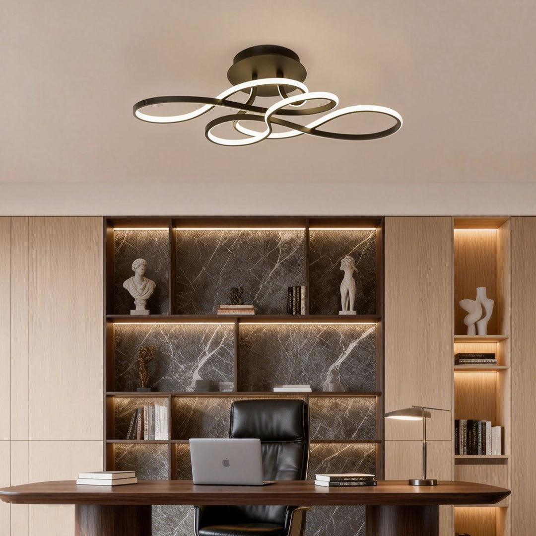 Curved LED ceiling light mounted above a home office desk with built-in shelving.