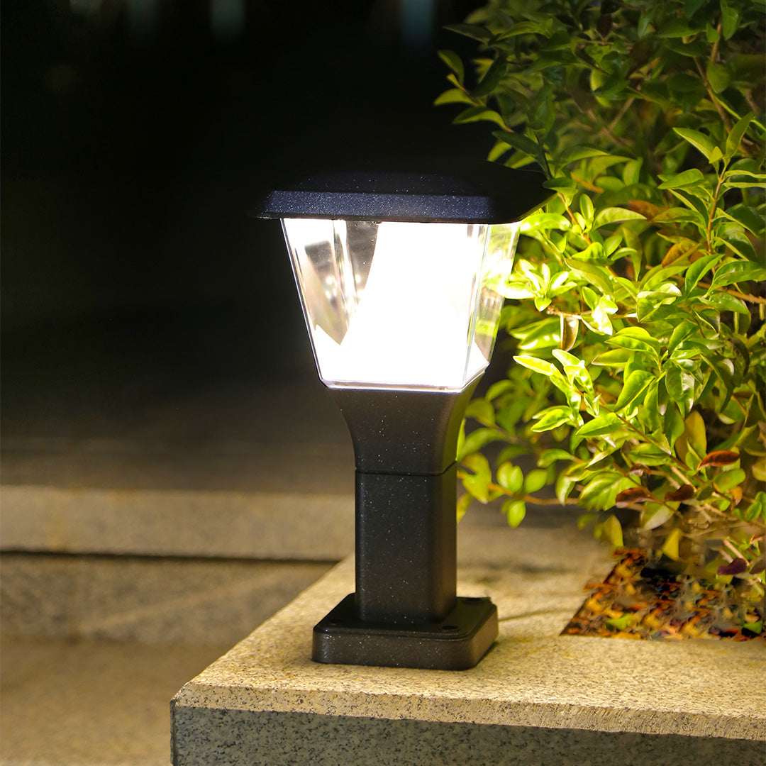 Lantern-style bollard lights providing pathway illumination along curved garden walkway