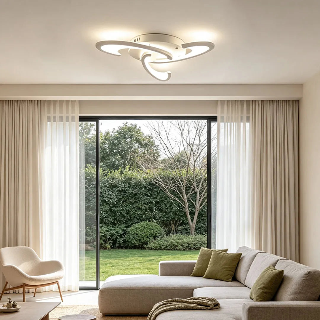 Curved LED ceiling light with an artistic swirl shape brightening a minimalist living room near large glass doors.