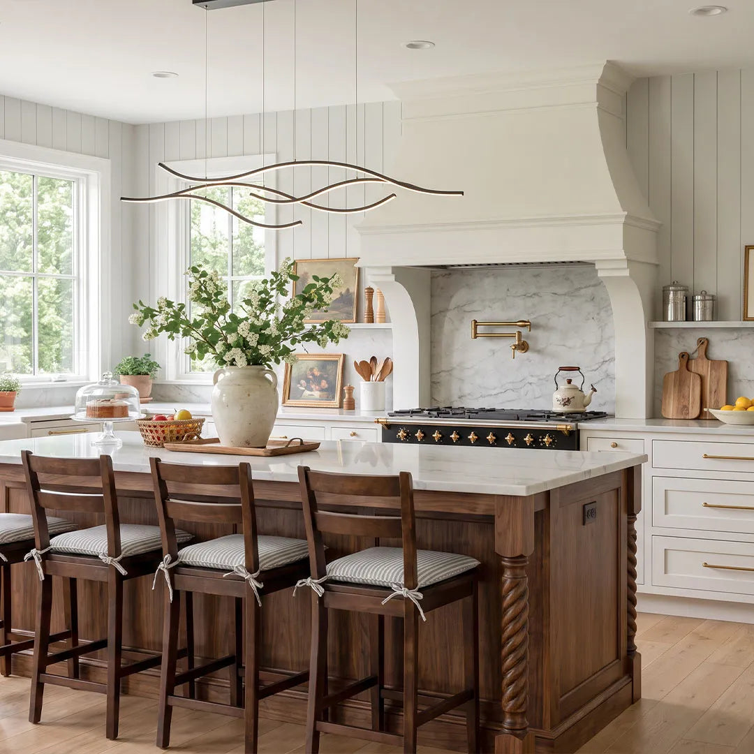 Curved LED pendant light suspended above a large kitchen island in a bright farmhouse-style kitchen.