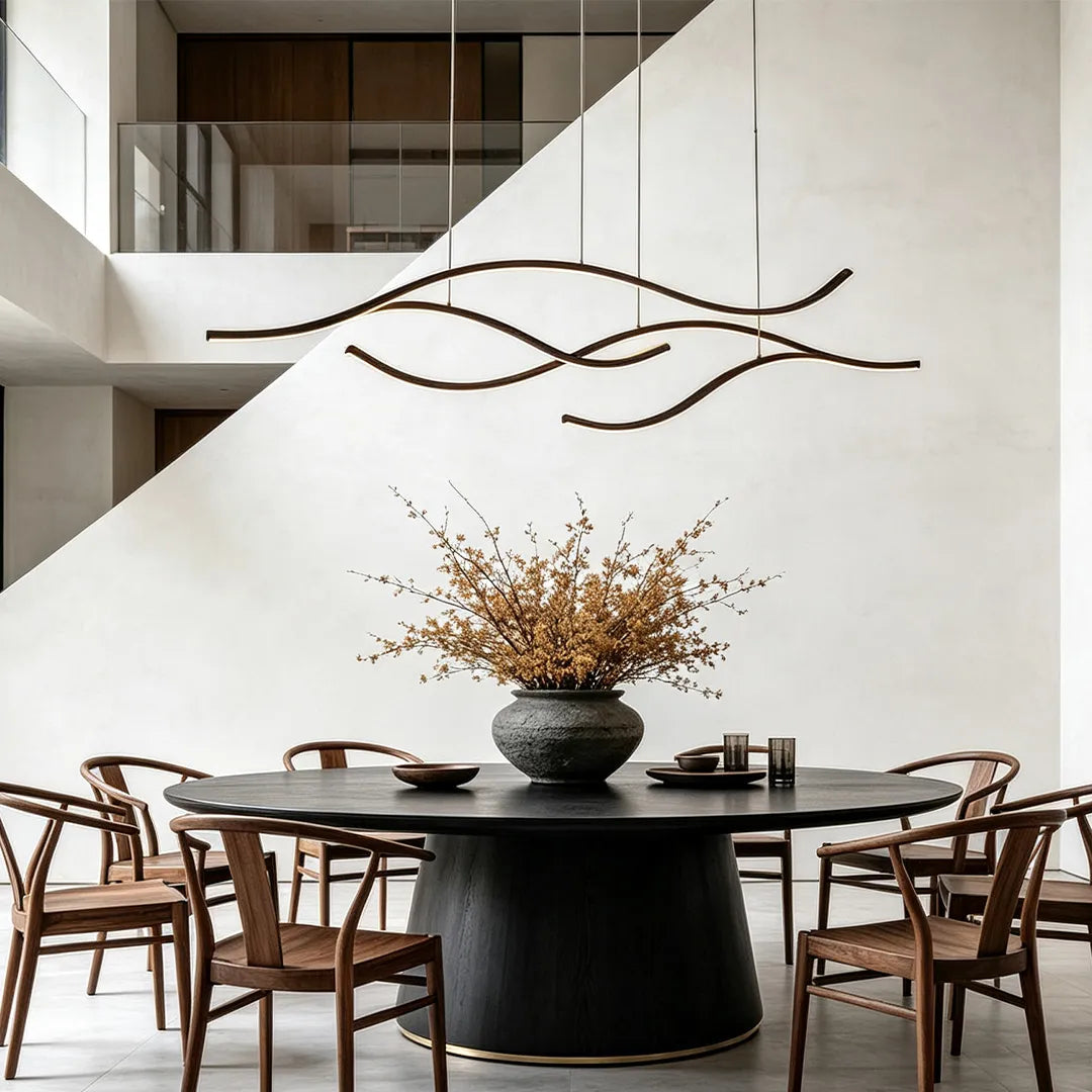 Curved LED pendant lights arranged above a round dining table in a spacious modern dining area.