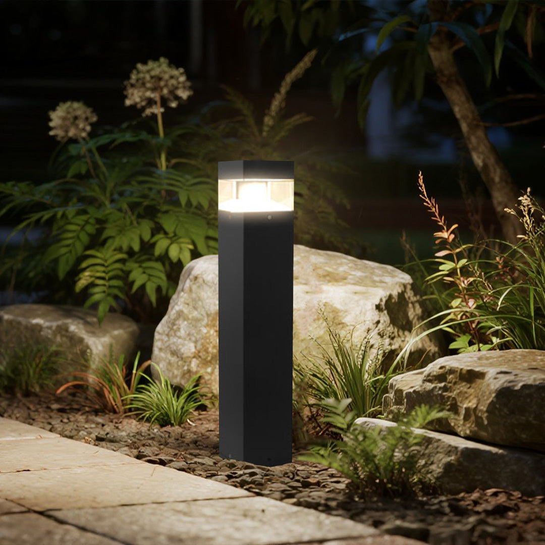 Modern square post lights creating ambient illumination in landscaped garden courtyard