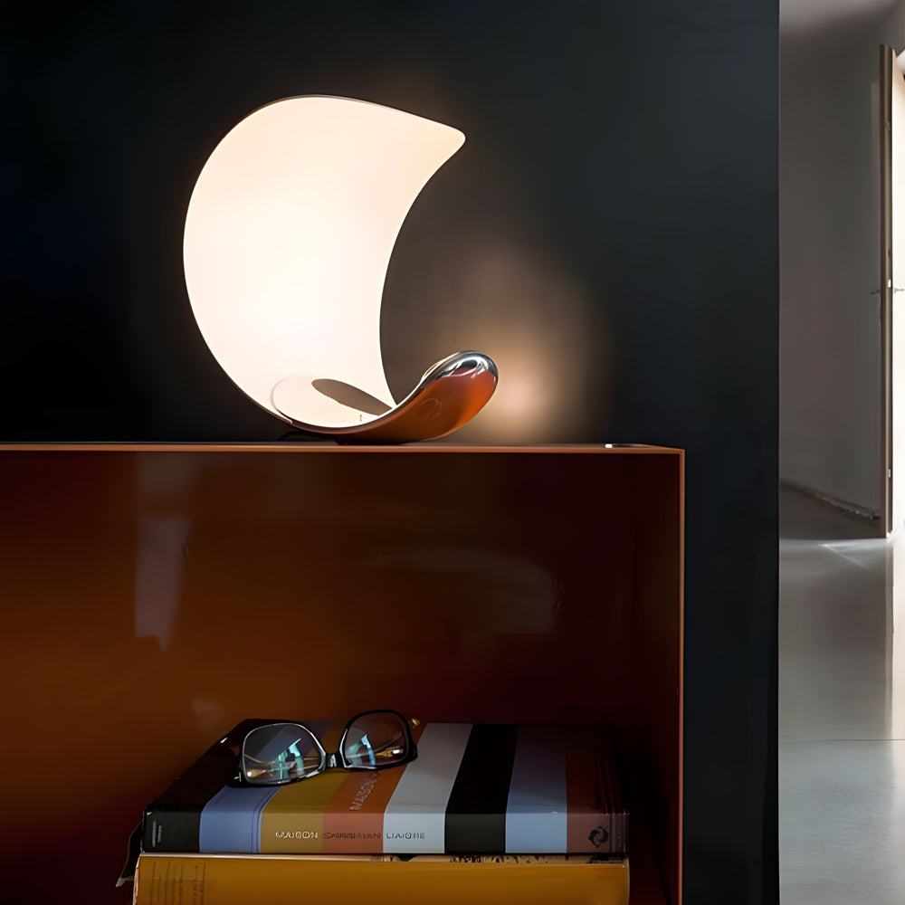 Curved silver end table lamp with a sleek design, providing warm illumination.