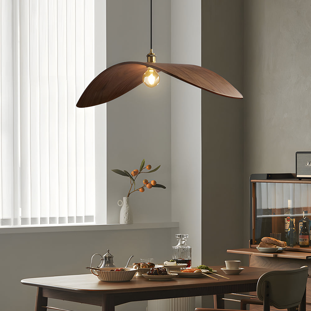 Curved wood pendant light with a brass accent, providing ambient lighting in a modern space.