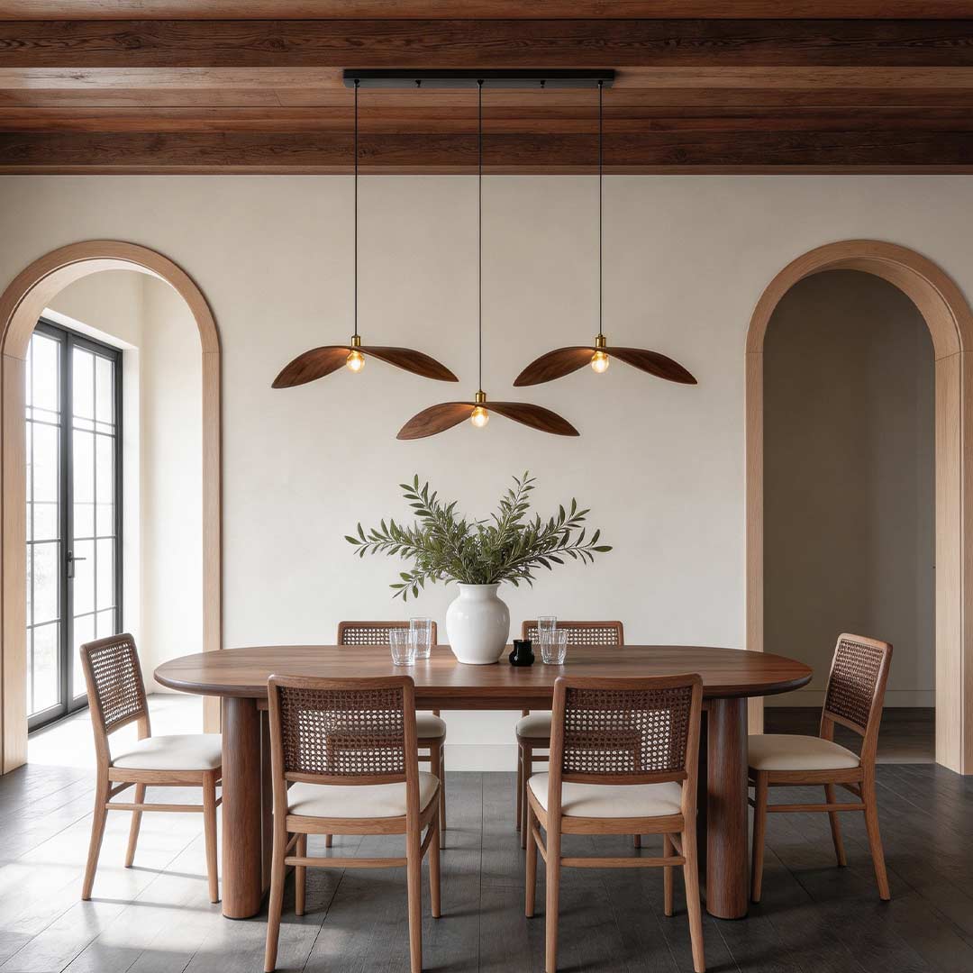 Curved wood pendant light hanging above a rustic wooden dining table in a modern interior.