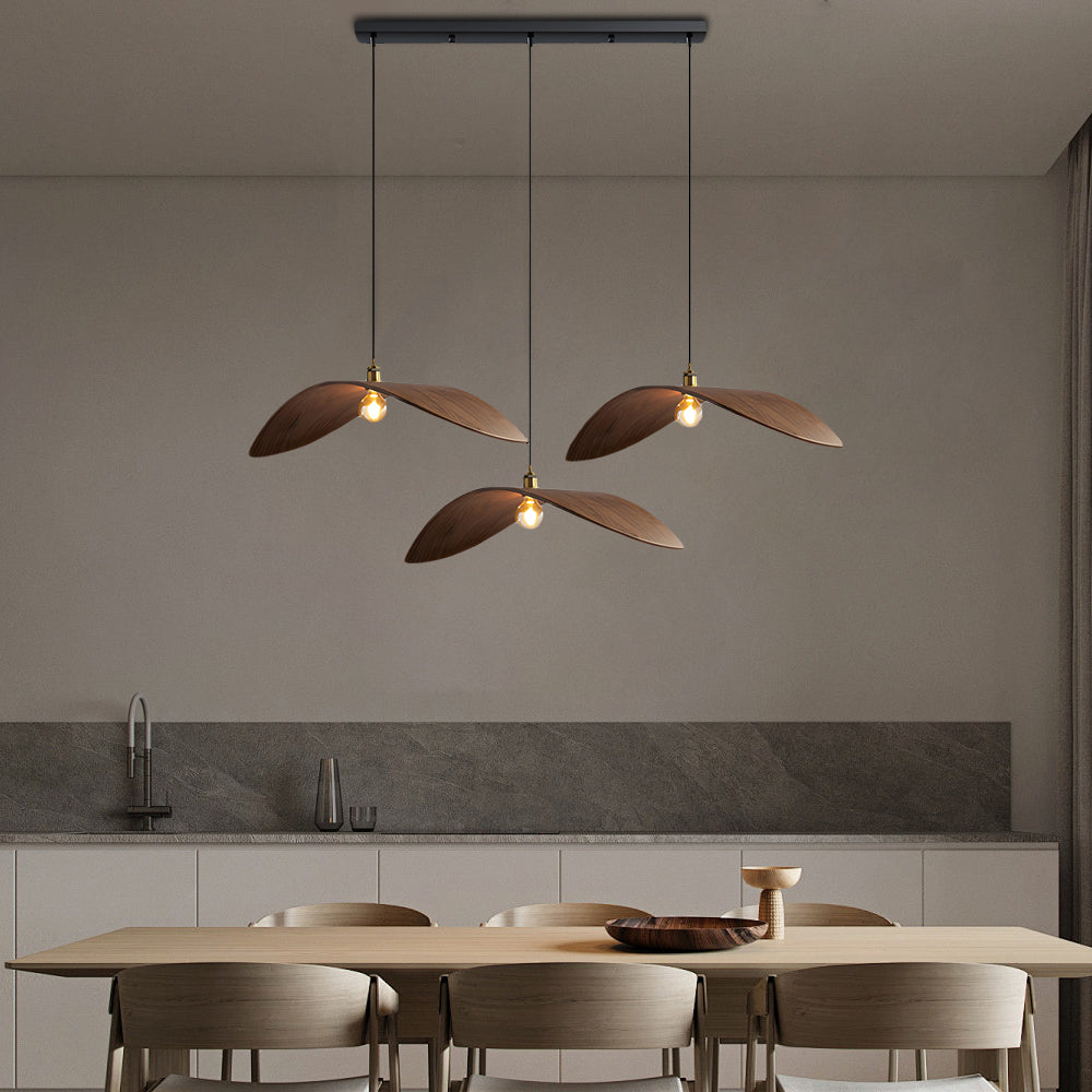 Three curved wood pendant lights aligned above a kitchen island in a modern home.