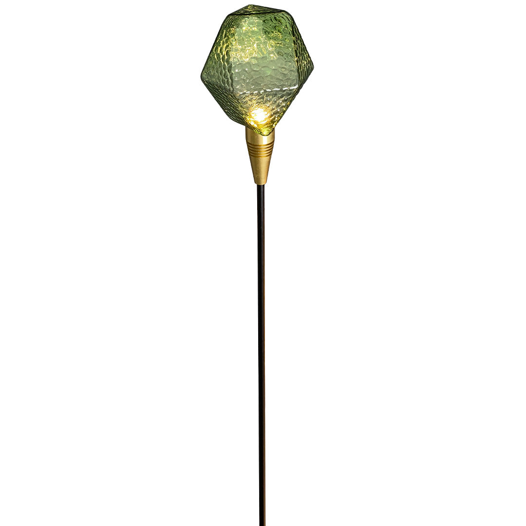 Bright amber cut-glass globe stake illuminating garden terrain, perfect for artistic landscape lighting pathway.