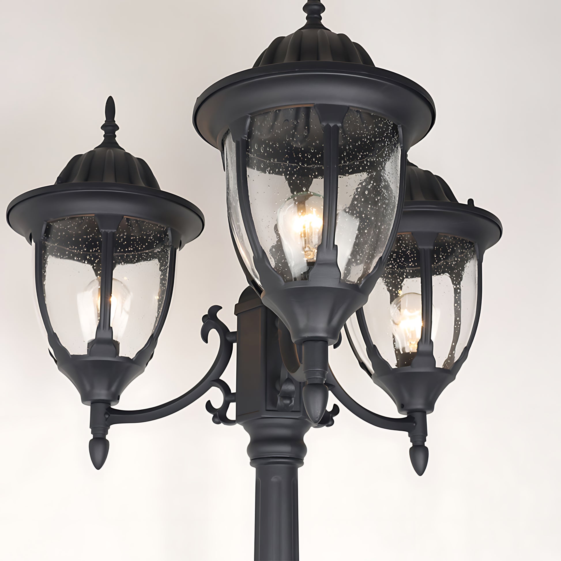 Close-up detail of ornate lamp heads showing decorative metalwork and glass globe design