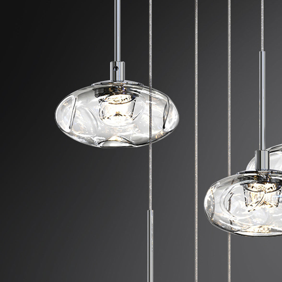 Modern small glass pendant lights with dark finish suspended in sleek residential hallway setting