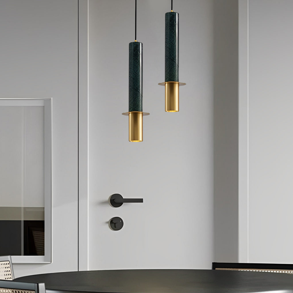 Staggered duo of dark green terrazzo cylinder pendant lights with gold finish in a minimal room.