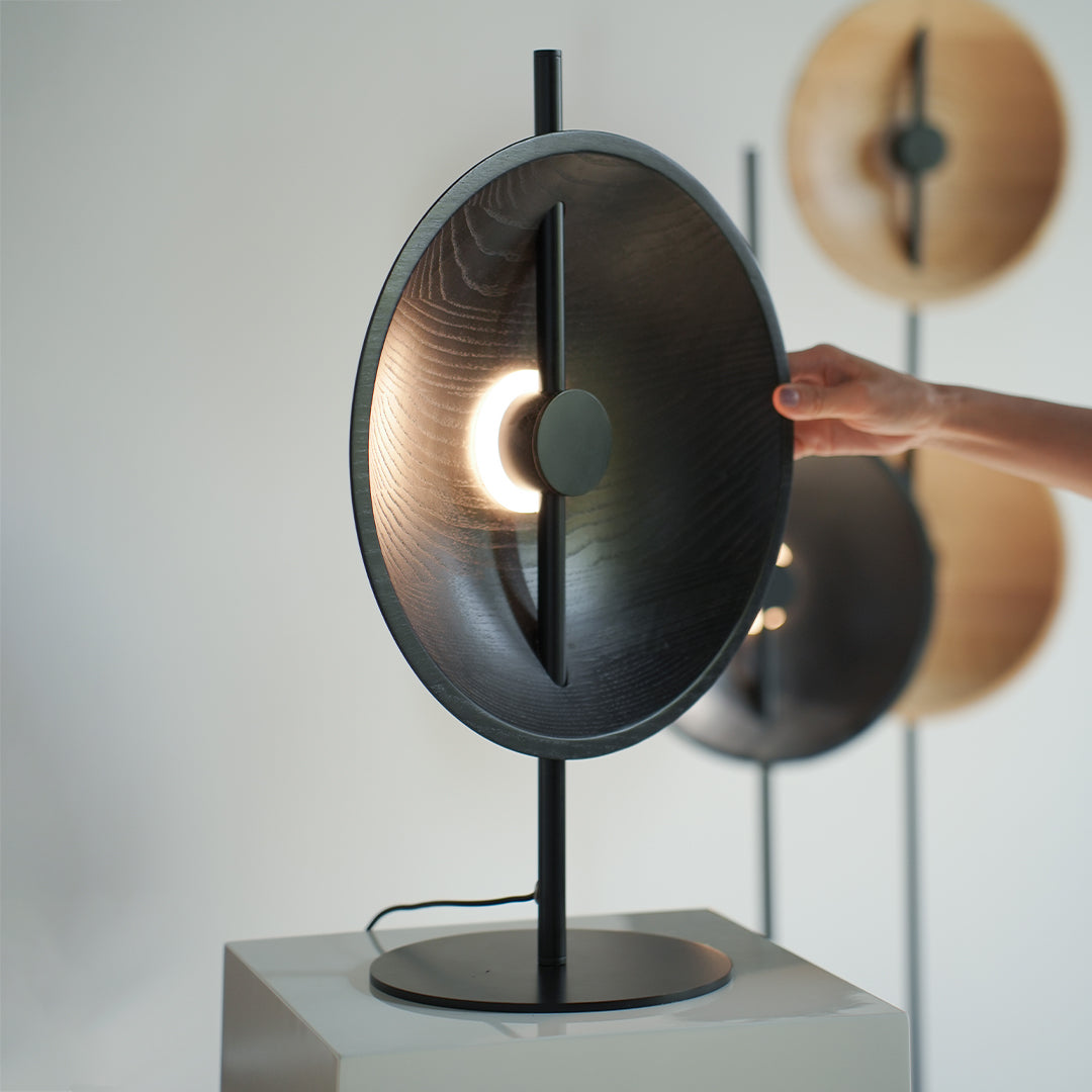 Dark wood modern table lamp with inner glowing ring and clean modern silhouette.