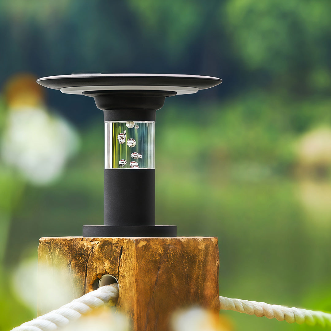 Daytime view of the solar post cap light installed on a rustic wooden post with a rope railing.