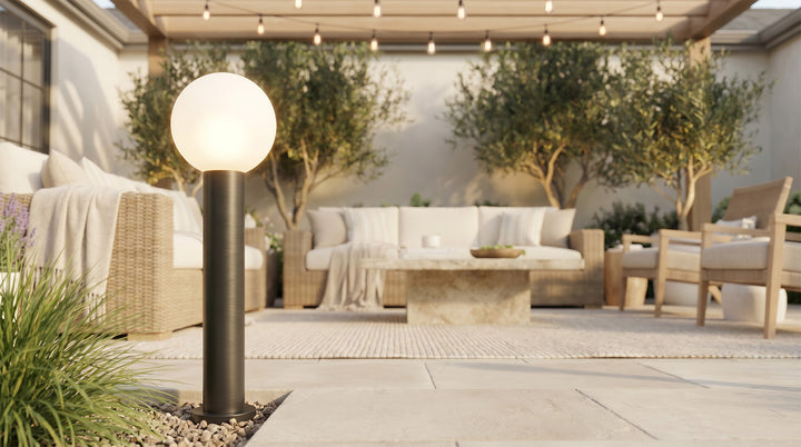 Round bollard lights with a spherical top, illuminating a garden pathway at dusk.