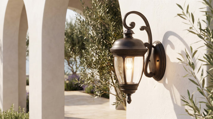 Black outdoor lantern sconce mounted beside a stone building entrance, providing classic and warm illumination.