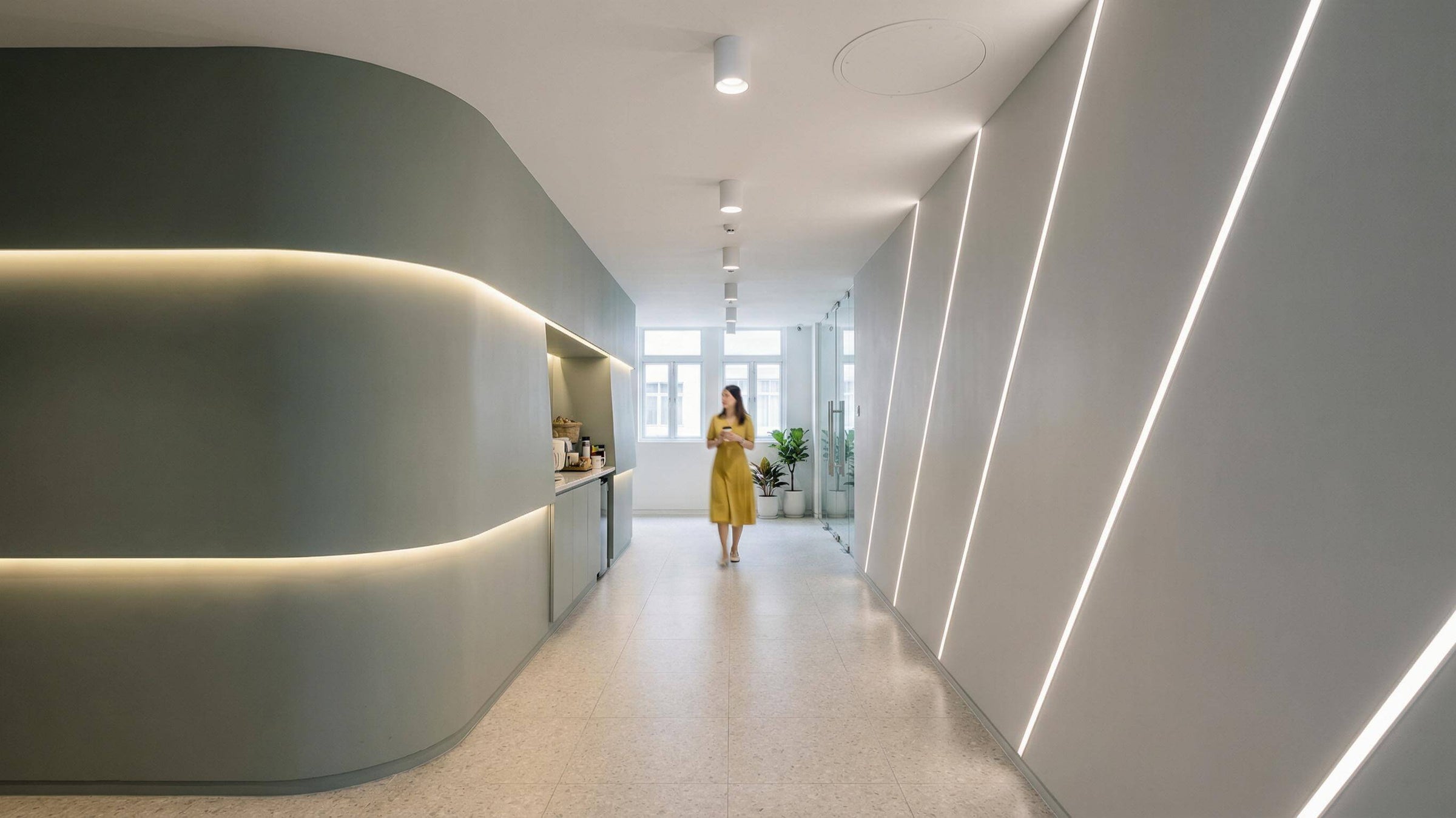 Contemporary circular pendant in a compact conference room, showing soft ambient coverage