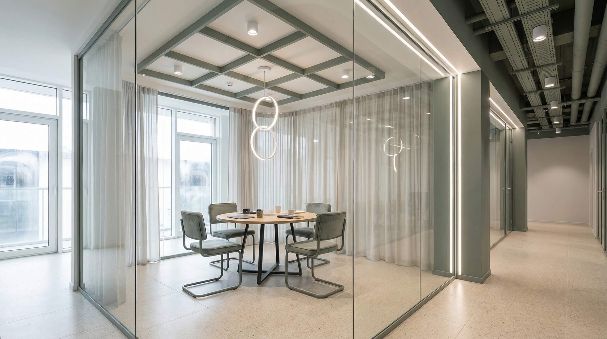  Modern small conference room lighting with a round pendant, showing even tabletop illumination