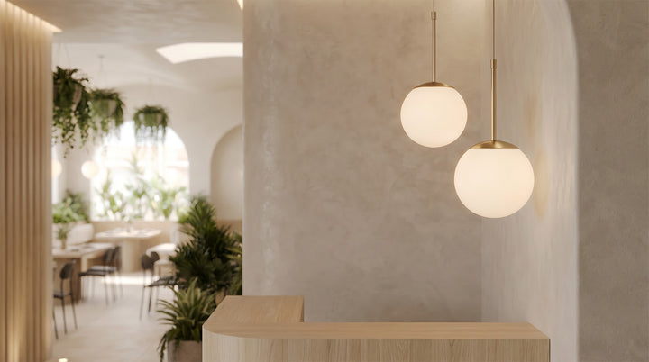 Elegant trio of White Faux Pendant Light globes over a modern marble island with wood cabinets.