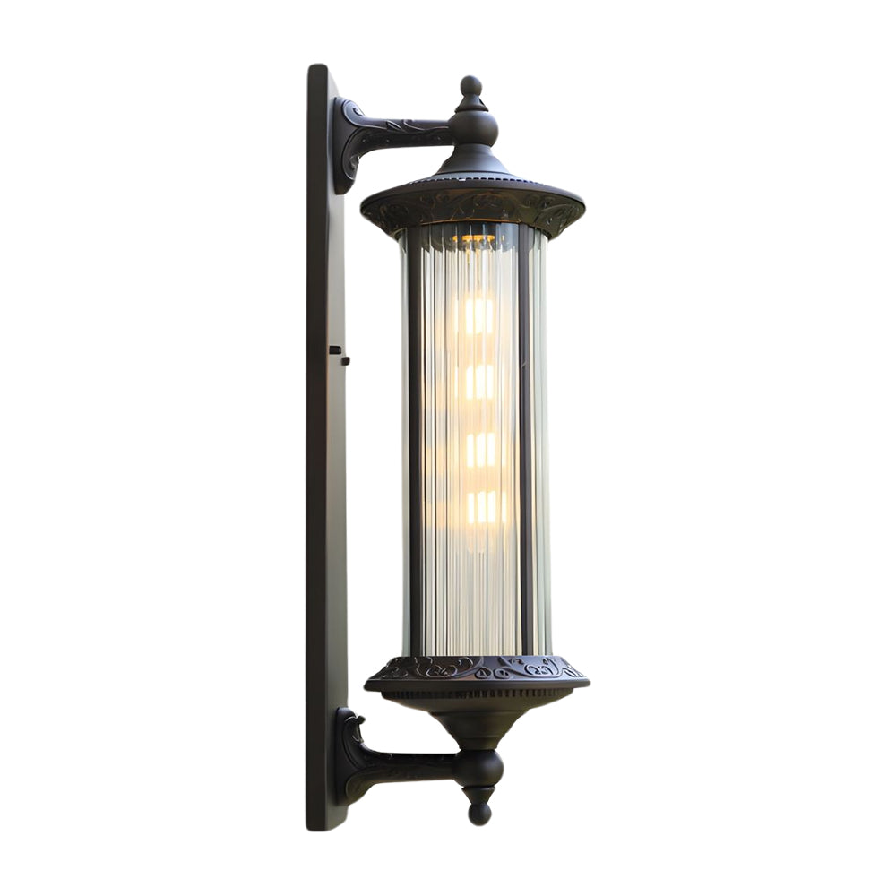 Tall black outdoor wall sconce with vertical ribbed glass cylinder and ornate mounting arm in heritage design