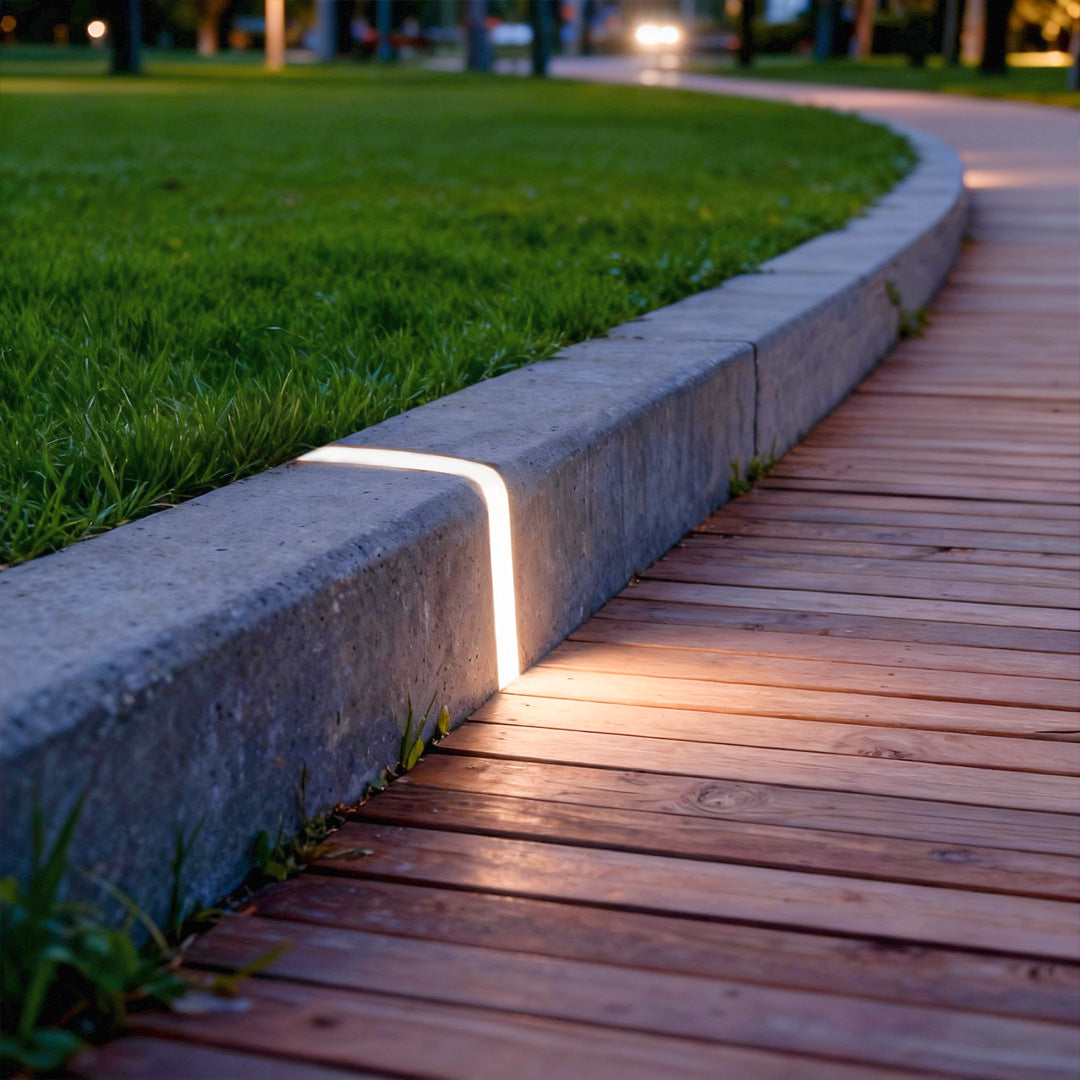 Deck lighting for steps integrated into stone border beside wooden walkway providing elegant pathway illumination