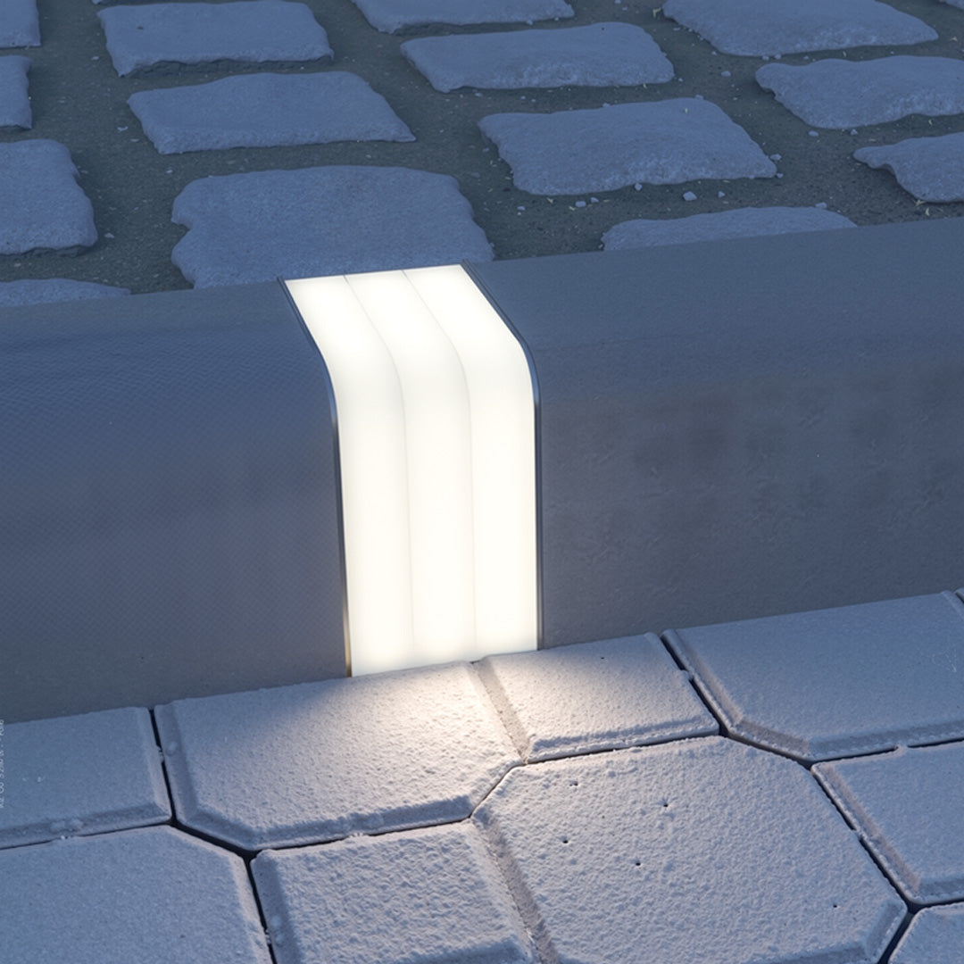 Deck lighting for steps positioned on stone pavers providing functional illumination for outdoor walking surfaces