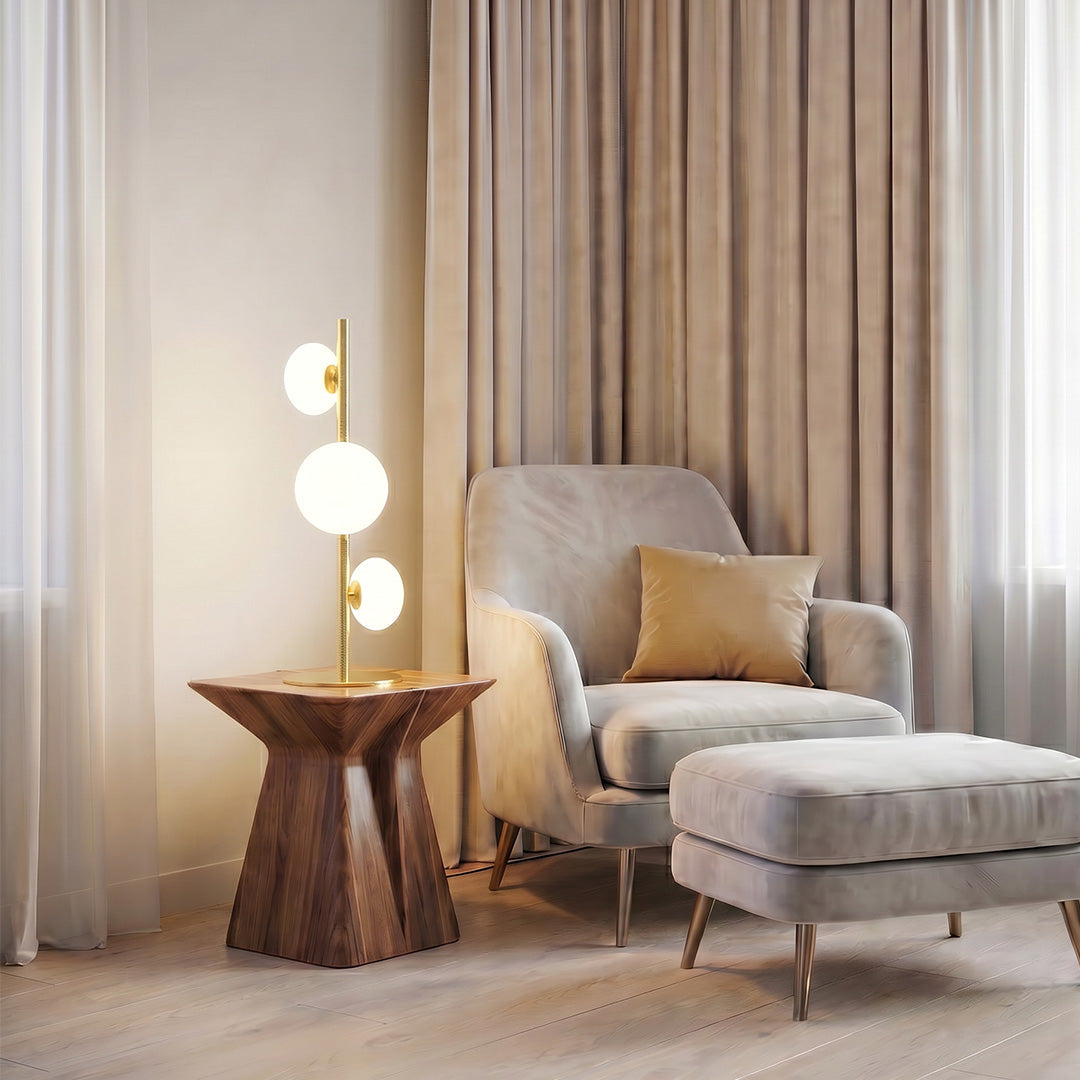 Decor floor lamp next to a lounge chair with soft fabric textures and neutral curtain background.
