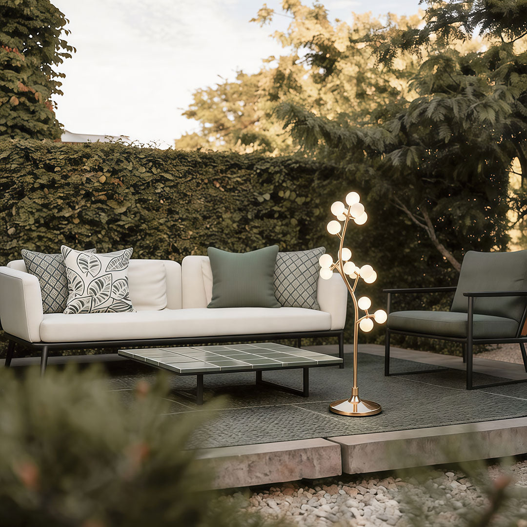 Decorate floor lamp with a stylish tree design, enhancing a modern patio with cushioned seating.