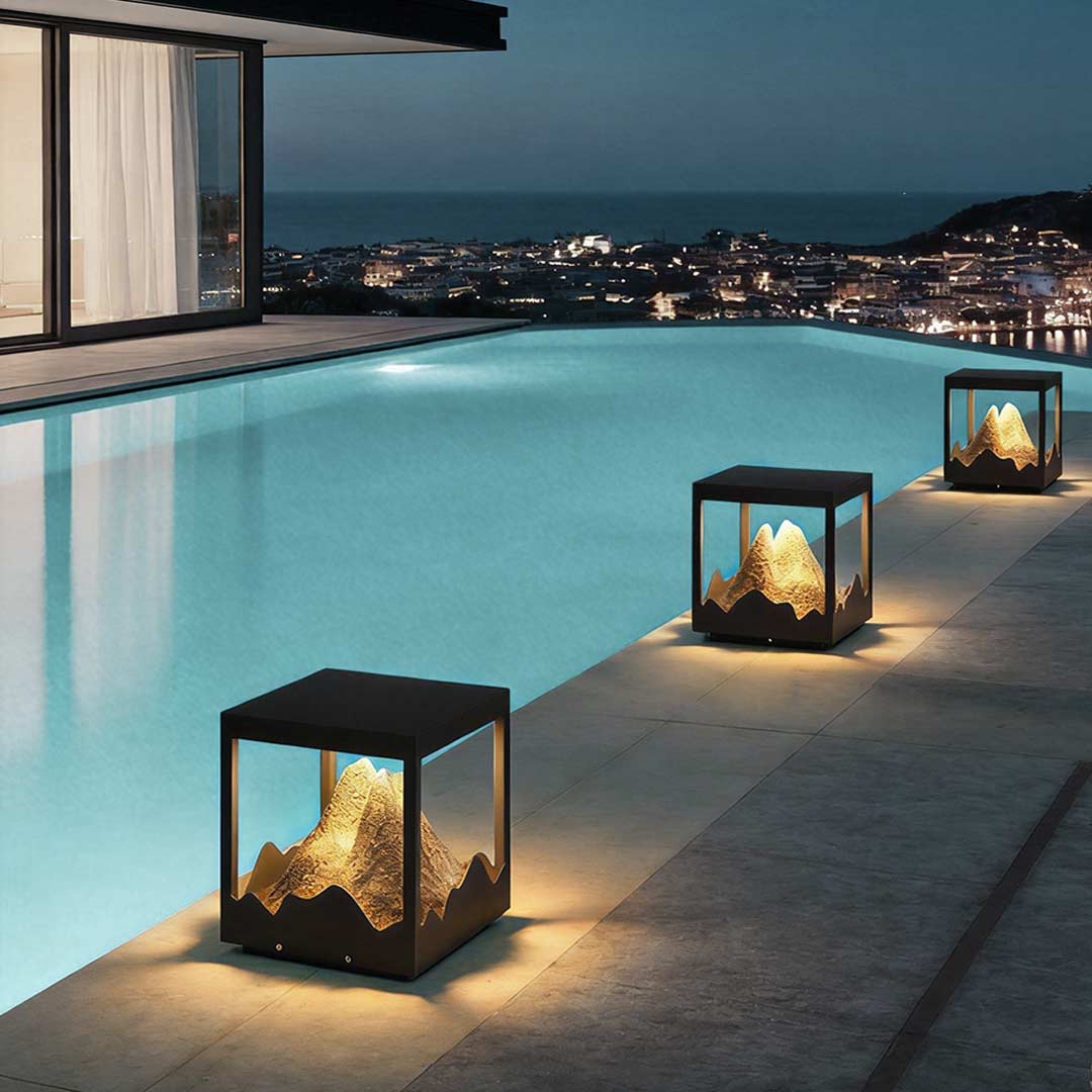 Decorate pillar light illuminating a modern poolside with elegant mountain-shaped glow.