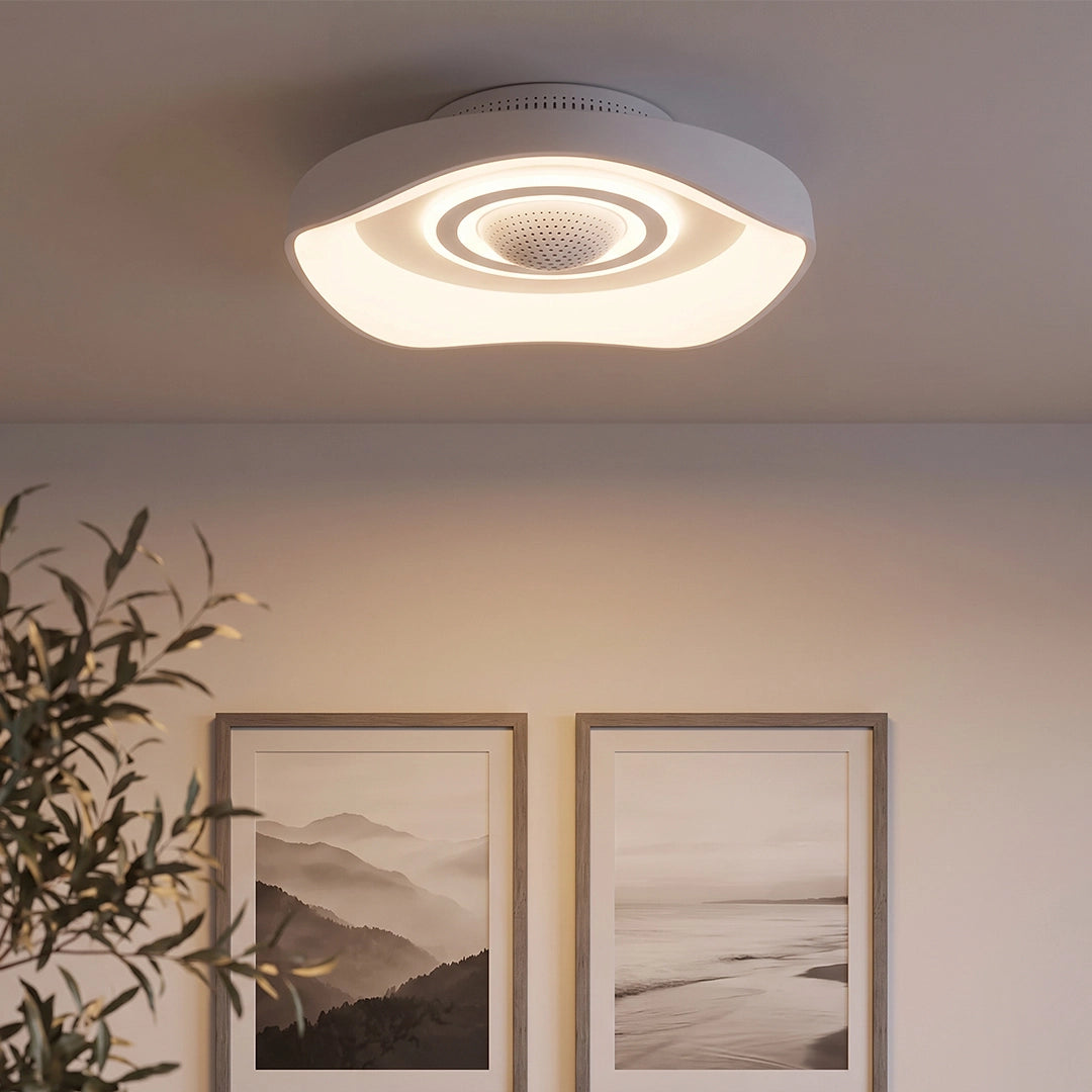 Modern decorative bladeless fan with light installed on a ceiling above framed wall art, featuring a layered circular design.