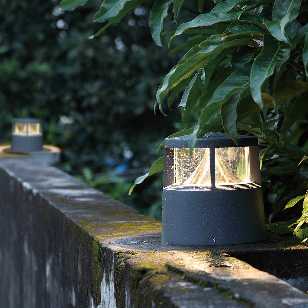 Decorative bollard lighting installed in garden setting creating ambient illumination among greenery