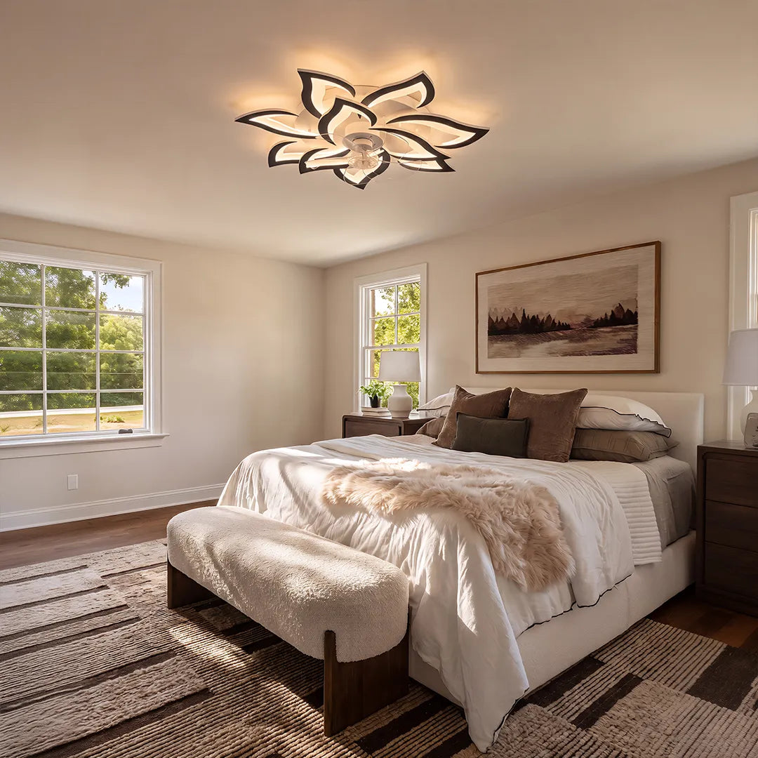 Decorative ceiling fans with lights mounted above a bright bedroom with large windows and neutral decor.