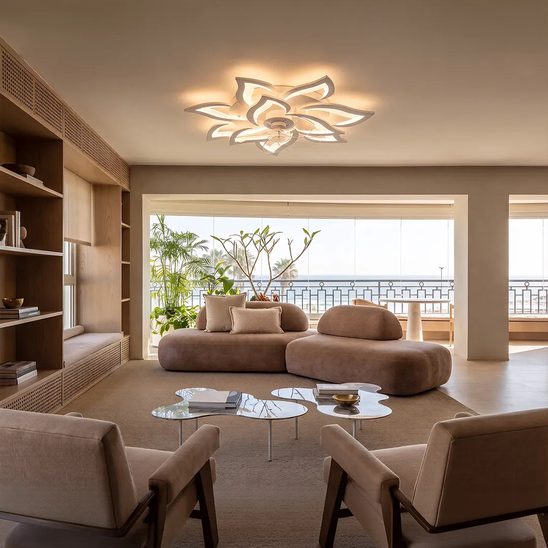 Decorative ceiling fans with lights installed in an open living room with shelving and balcony views.