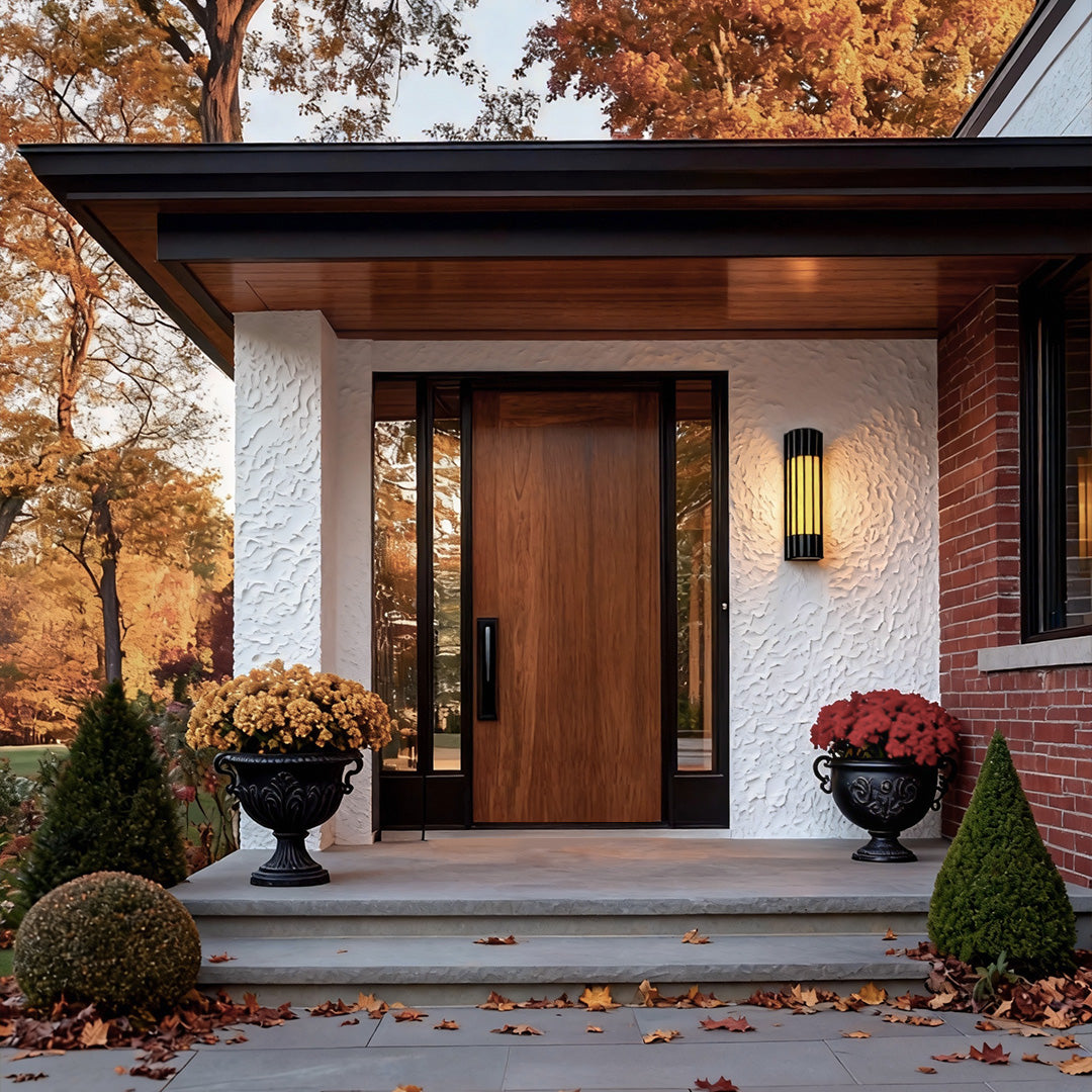 Decorative copper outdoor wall lights illuminating a grand doorway, creating a welcoming atmosphere for visitors.