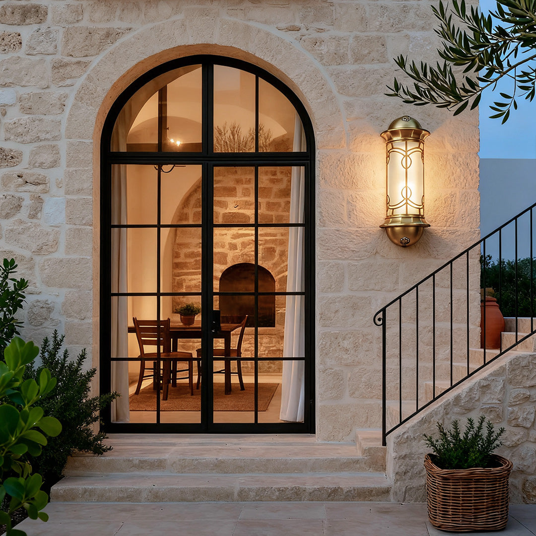 Decorative copper outdoor wall sconce illuminating a grand entrance, creating a welcoming ambiance for visitors.