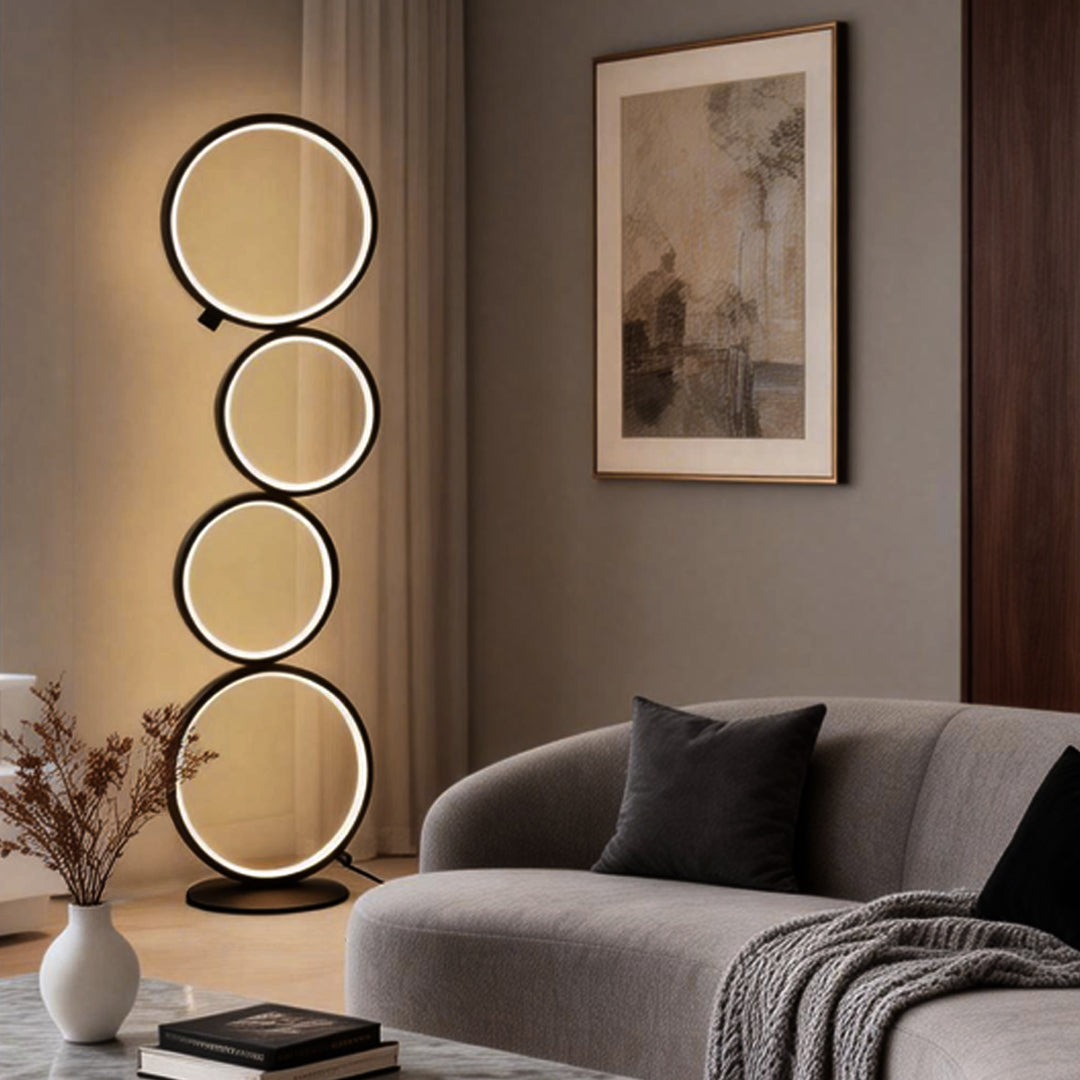 Decorative floor lamps featuring stacked circular lights, illuminating a stylish living room with gray sofa.