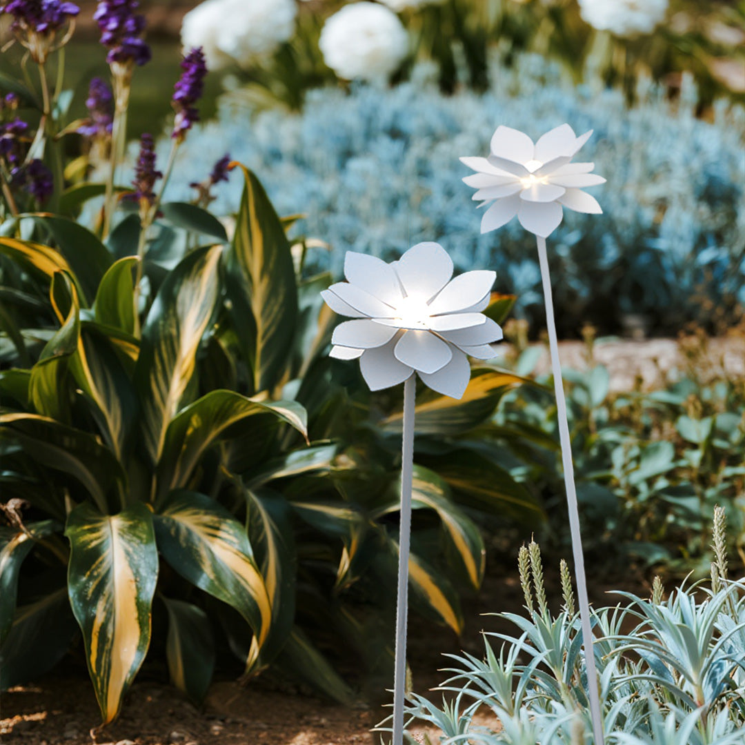 Decorative white flower landscape garden lights nestled among colorful foliage and ornamental plants in natural setting