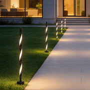Decorative garden lighting lining a modern outdoor walkway beside a contemporary home at dusk.