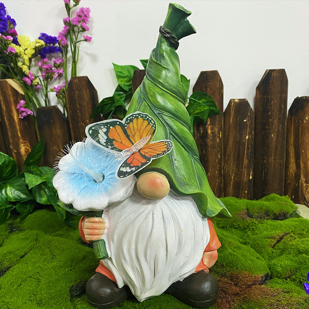 Decorative gnome with blue illuminated flower positioned among moss and wooden fence backdrop