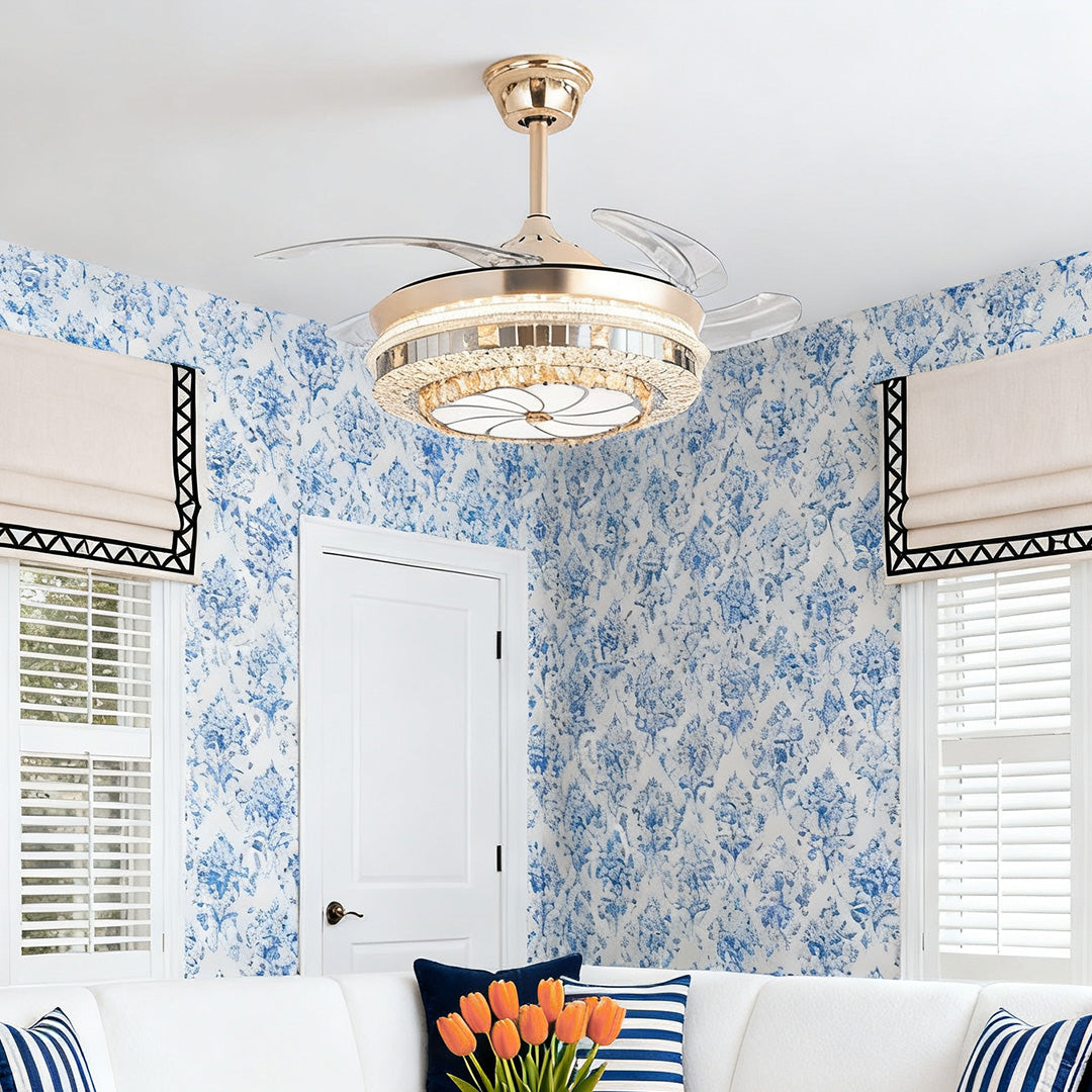 Decorative gold ceiling fan with light fixture in a bedroom with blue floral wallpaper 