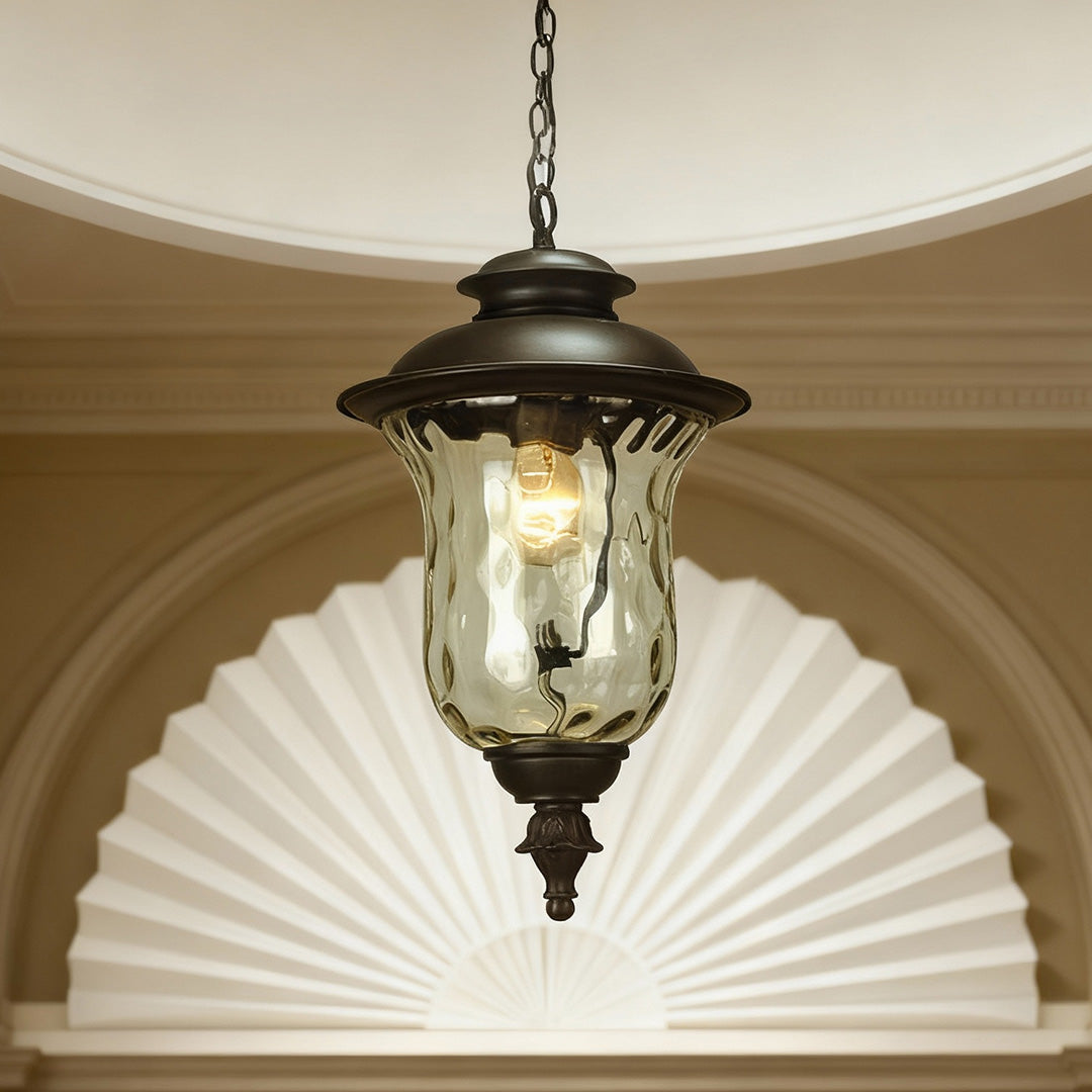 Decorative industrial metal pendant light glowing in arched alcove with white fan-shaped backdrop