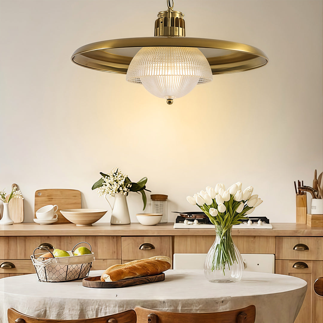 Decorative iron pendant light fixture with scalloped brass shade illuminating bright farmhouse kitchen interior