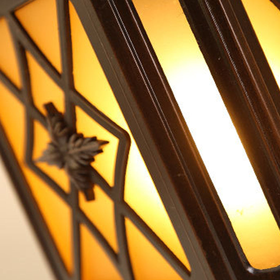 Decorative lantern creating geometric shadows from outside pillar lights with lattice glass design and warm illumination