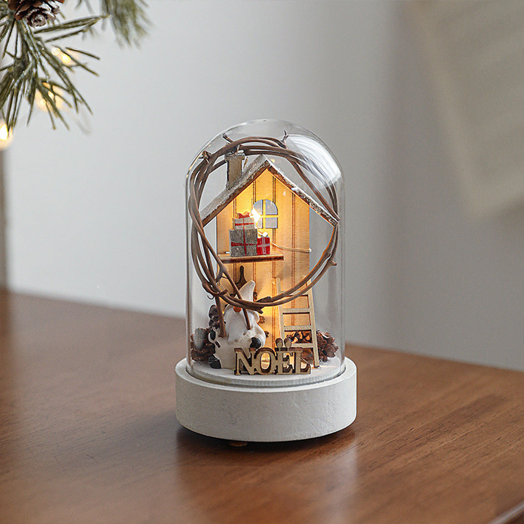 Decorative led table lamp with white base and glass cloche featuring illuminated miniature arched doorway house scene