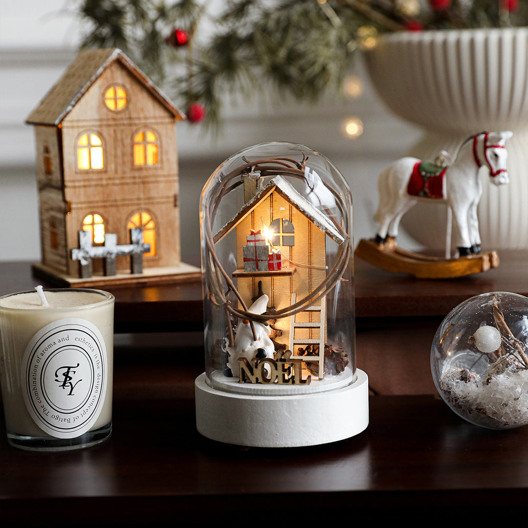 Multiple decorative led table lamp pieces with illuminated house designs arranged in festive holiday display grouping