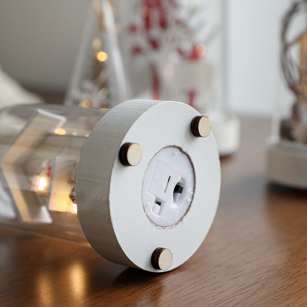 White spherical decorative led table lamp with cutout snowman design casting warm glow in holiday setting