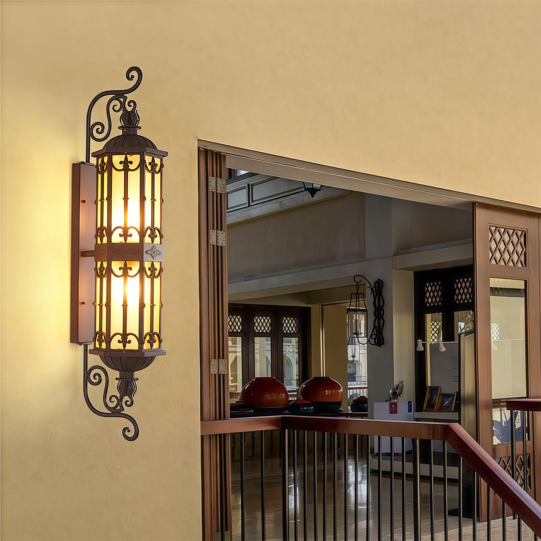 Decorative LED wall light with a vintage feel, lighting up a front yard wall.