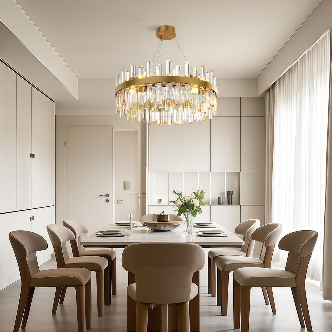Decorative luxury crystal chandelier creating warm ambiance in bright dining room with upholstered chairs.